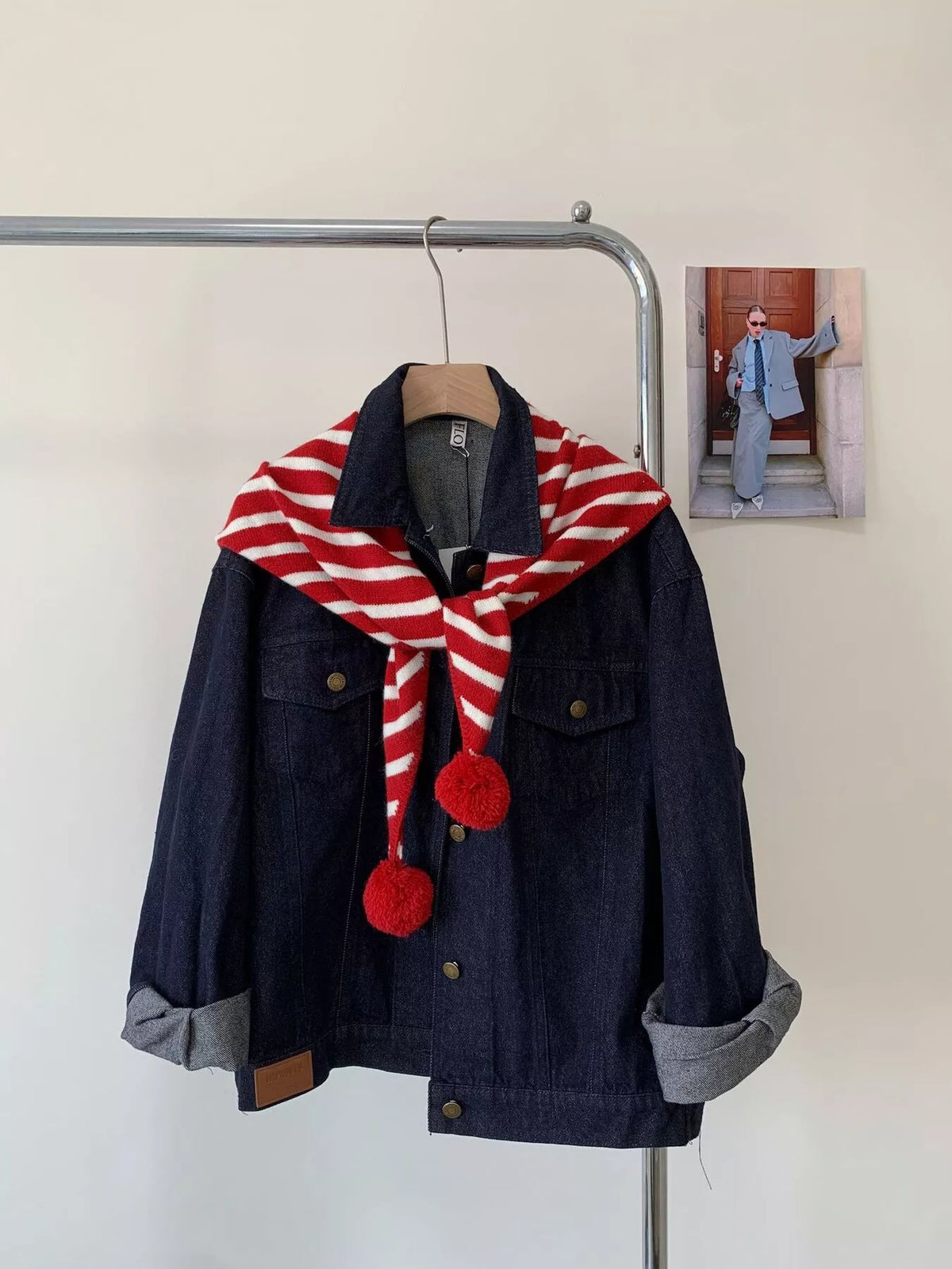 Unisex Striped Knitted Scarf with Pom-Poms — red striped scarf tied over a dark jacket with pom-poms visible