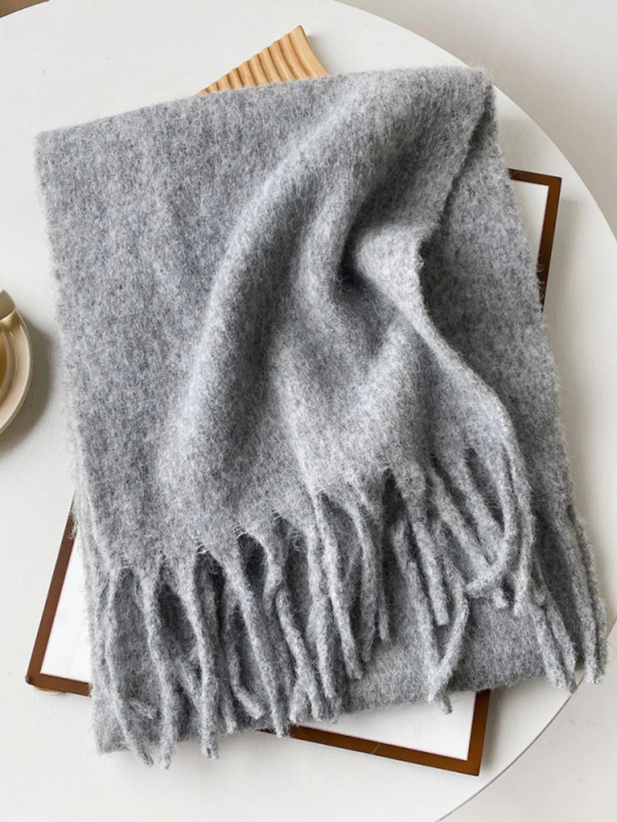 Unisex Extra Long Fringe Scarf — gray extra long scarf folded on a pale surface