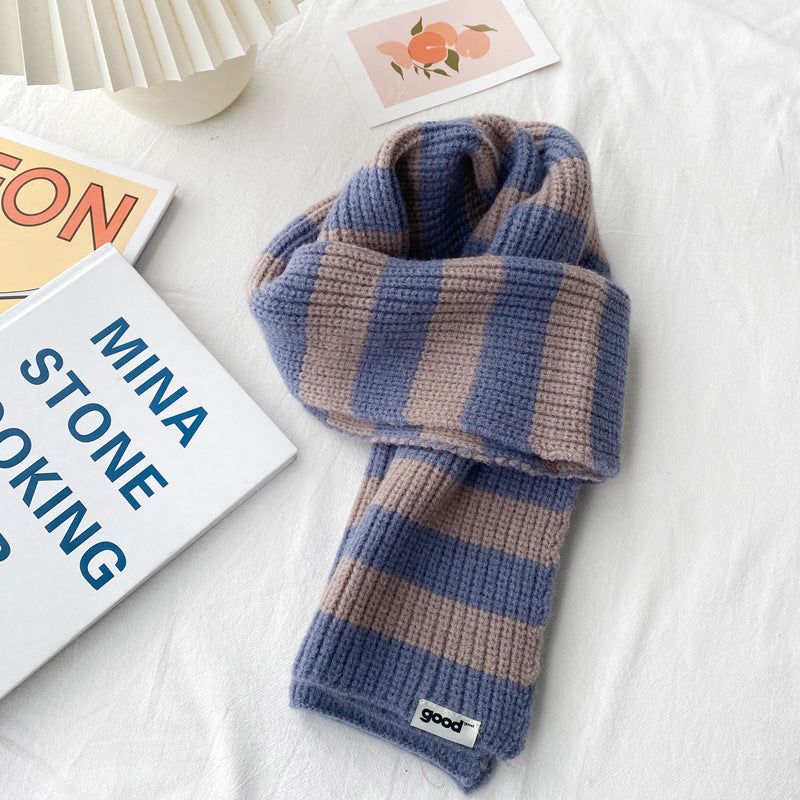 Muted blue and beige striped scarf in a knotted arrangement