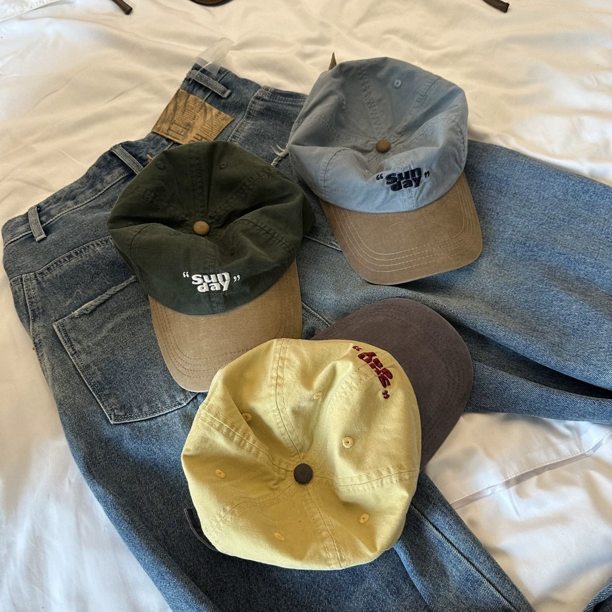 Four contrast-brim cotton baseball caps styled with denim