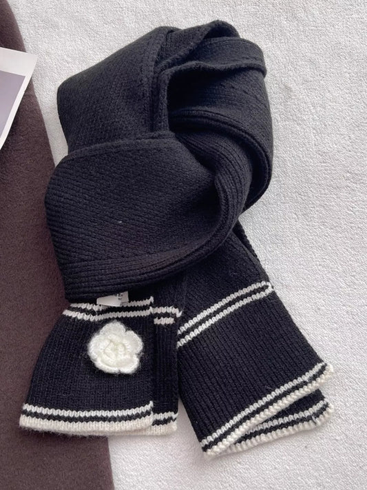 Women's Contrast Trim Knitted Scarf with Camellia Decor — black scarf tied to display pale stripes and camellia decoration