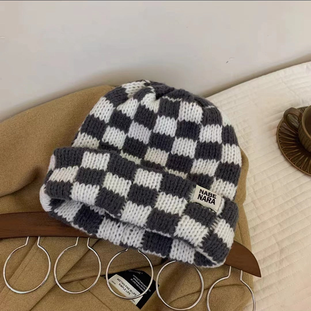 Gray and white checkerboard beanie shown with ribbed edge