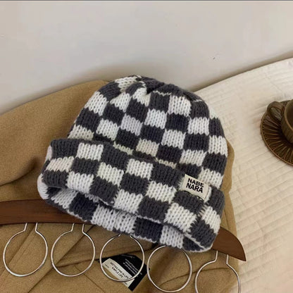Gray and white checkerboard beanie shown with ribbed edge