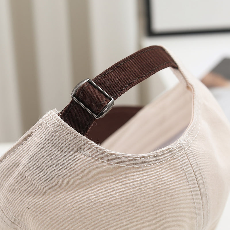 Close-up of the brown adjustable strap and metal buckle on Choo Choo cap