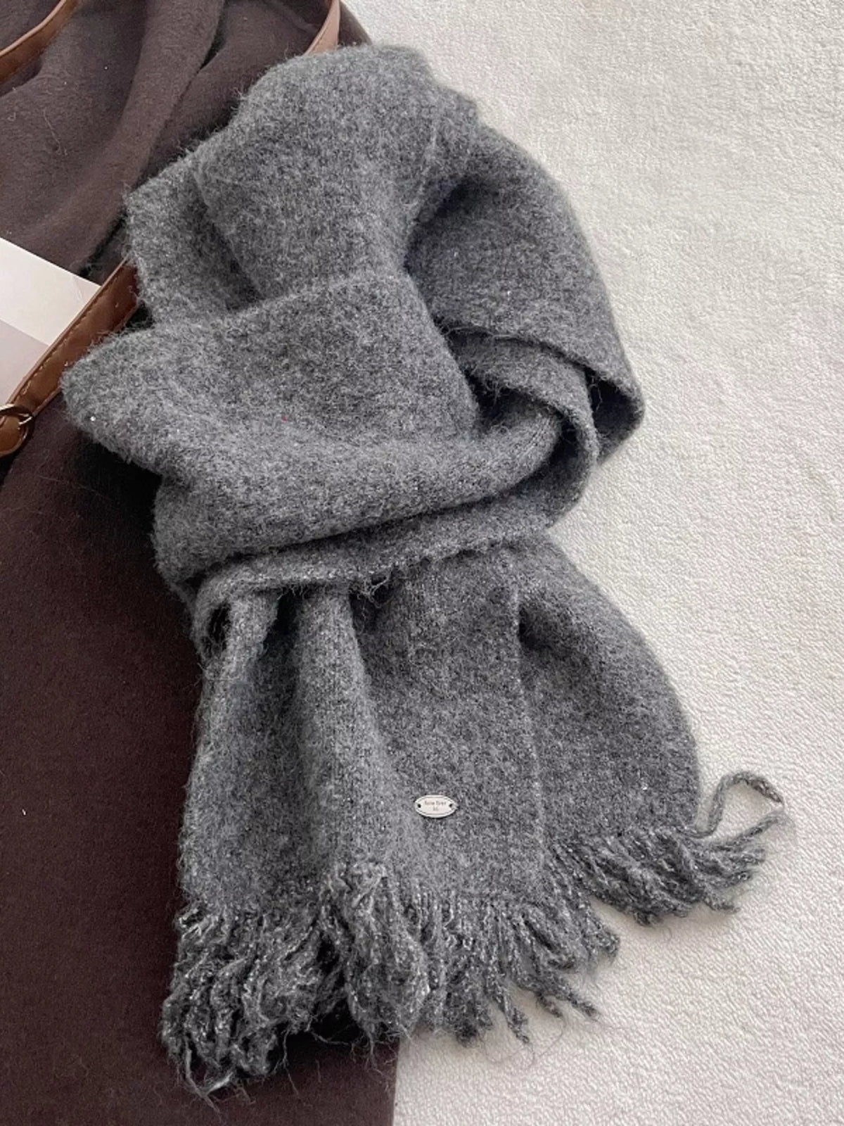 Unisex Fringe Hem Knitted Scarf — gray knitted scarf loosely knotted on a flat surface