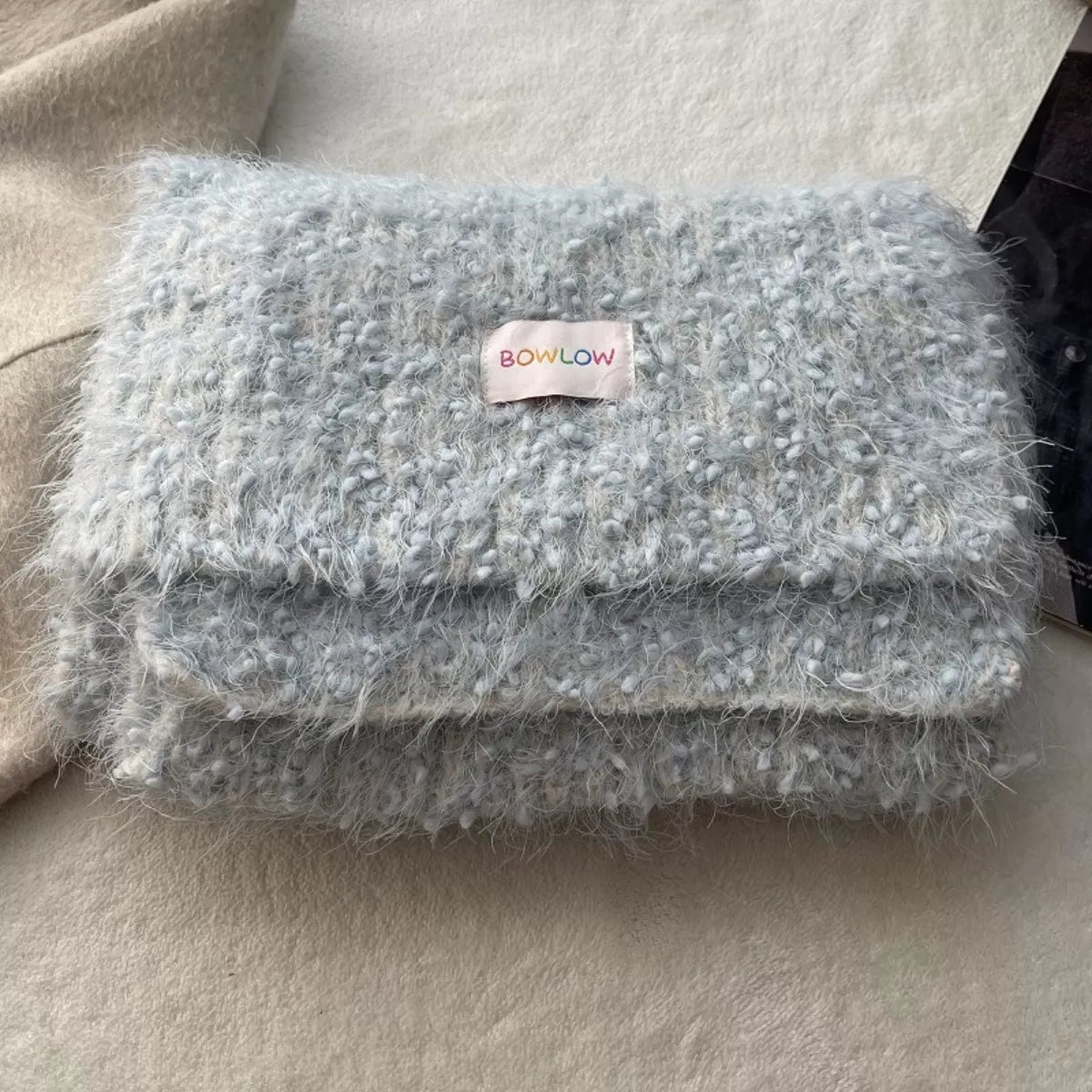 Unisex Soft Plush Winter Warm Scarf — folded pale blue scarf with small label