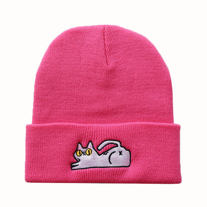 Bright pink cuffed beanie with reclining cat embroidery