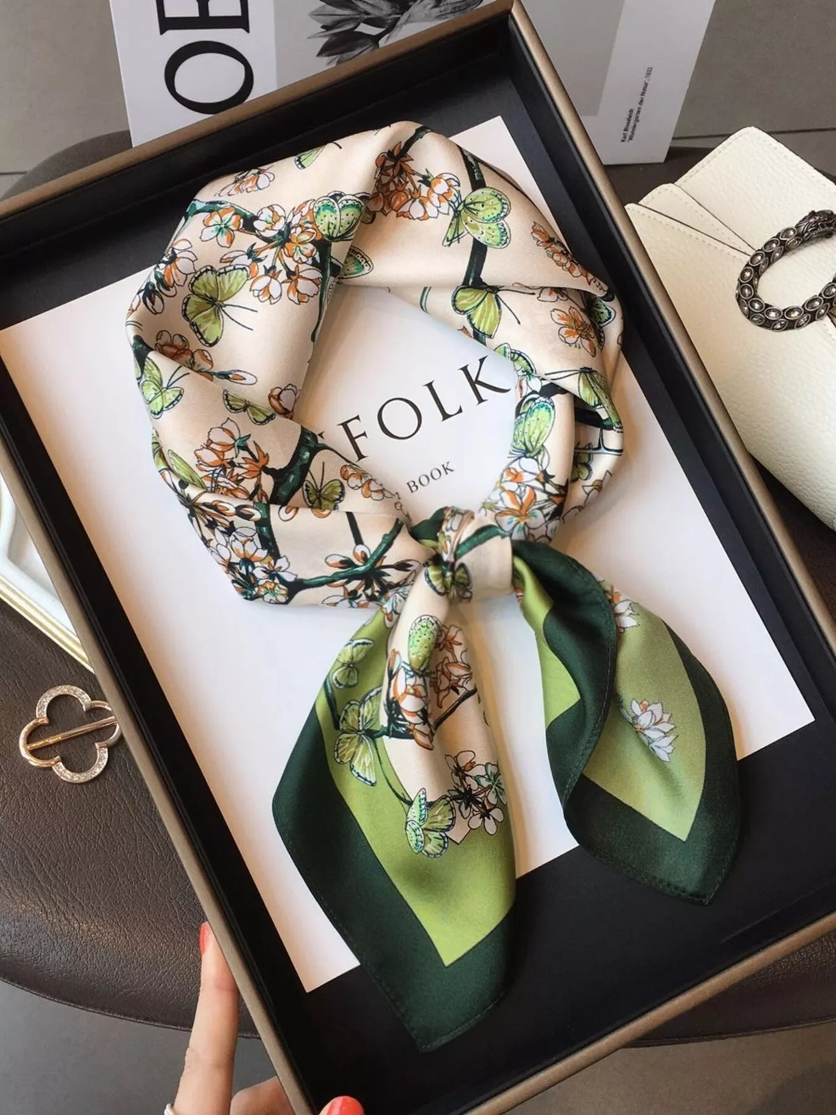 Unisex Floral Print Silk Scarf — green bordered floral silk scarf tied on a dark surface