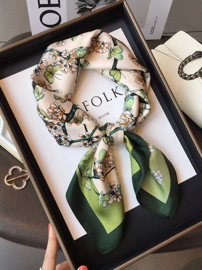 Unisex Floral Print Silk Scarf — green bordered floral silk scarf tied on a dark surface