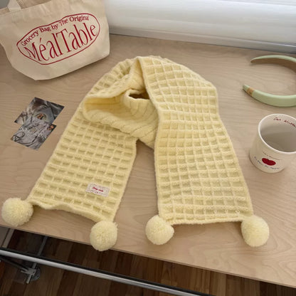 Unisex Waffle Knit Pom-Pom Scarf — creamy yellow scarf draped with pom-pom tips