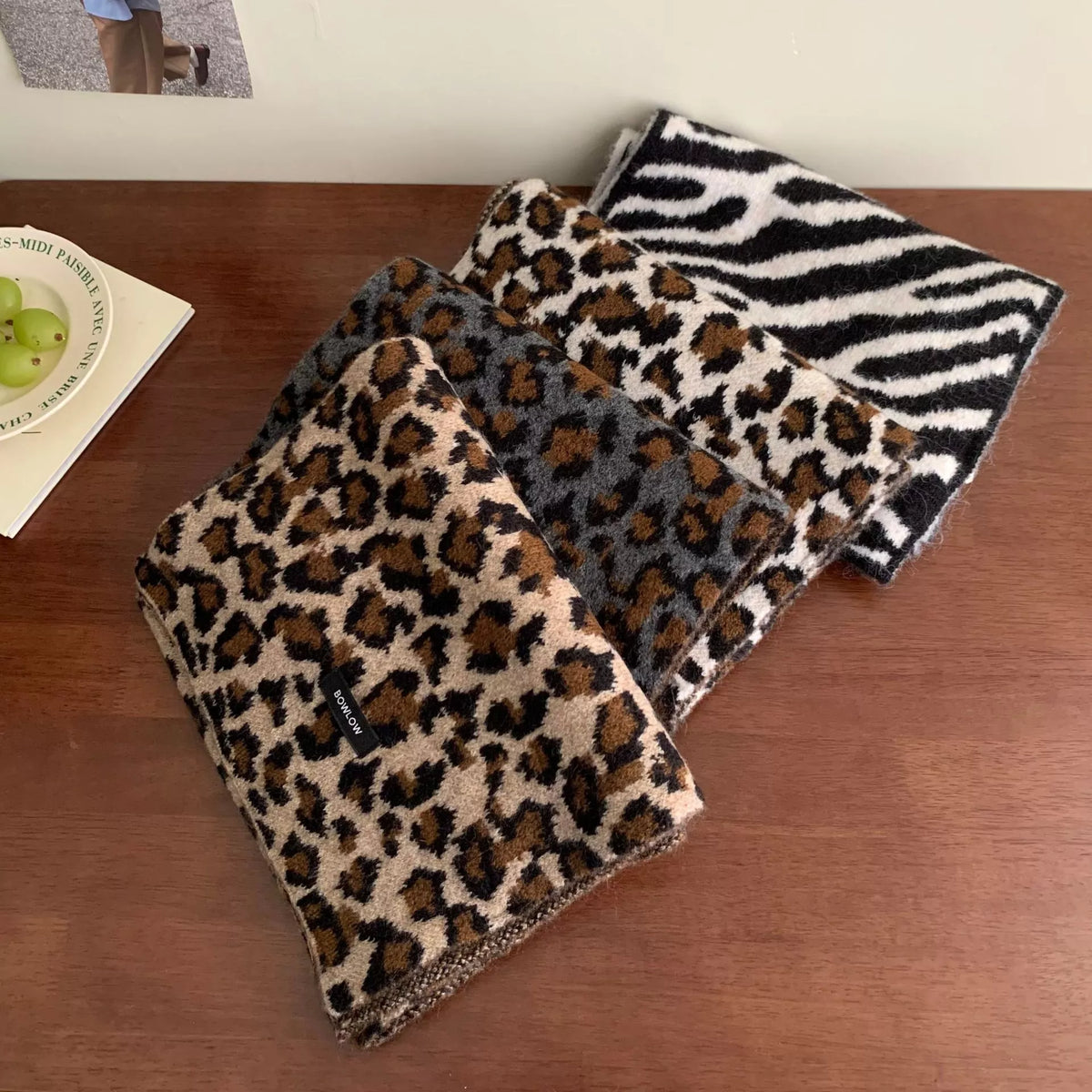 Unisex Animal Print Wool Scarf — leopard patterned scarf folded on a wooden surface