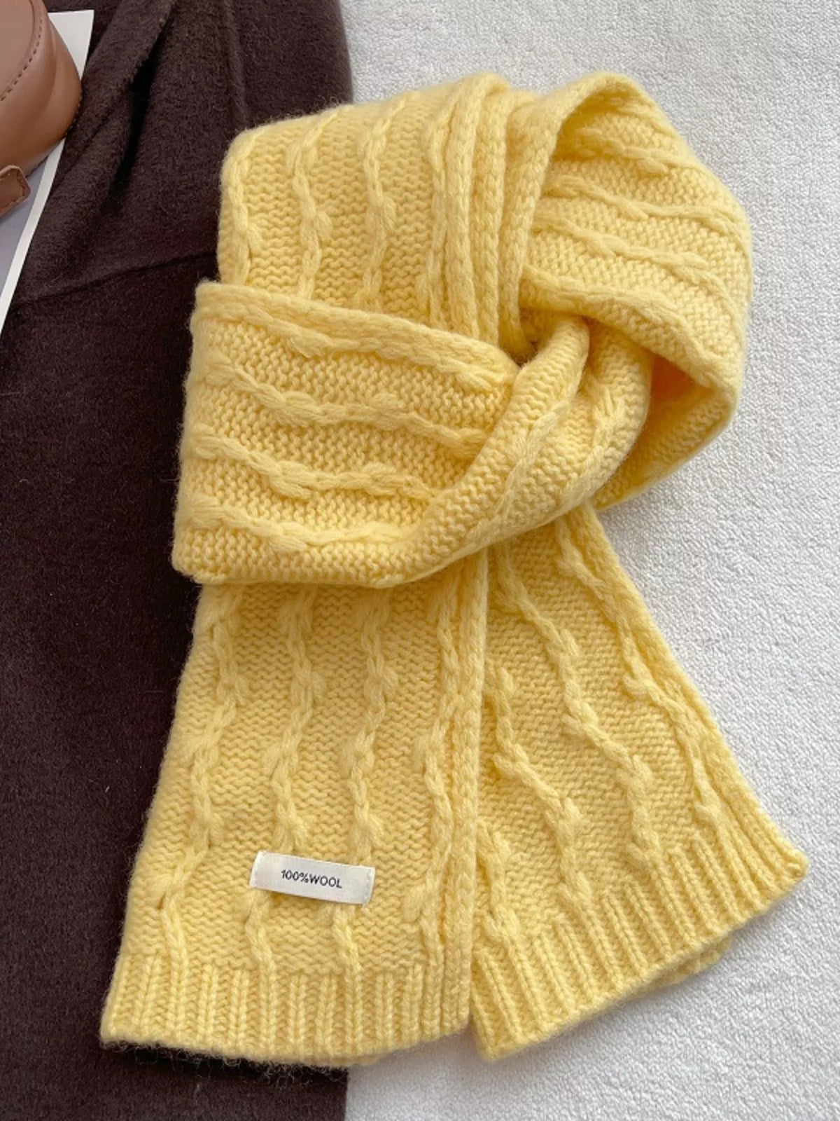 Unisex Wool Cozy Cable Knit Scarf — yellow scarf folded into a loop on a neutral surface