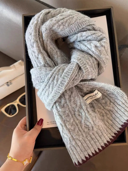 Unisex Cozy Cable Knit Scarf with Contrast Trim — gray knitted scarf held to show cable pattern