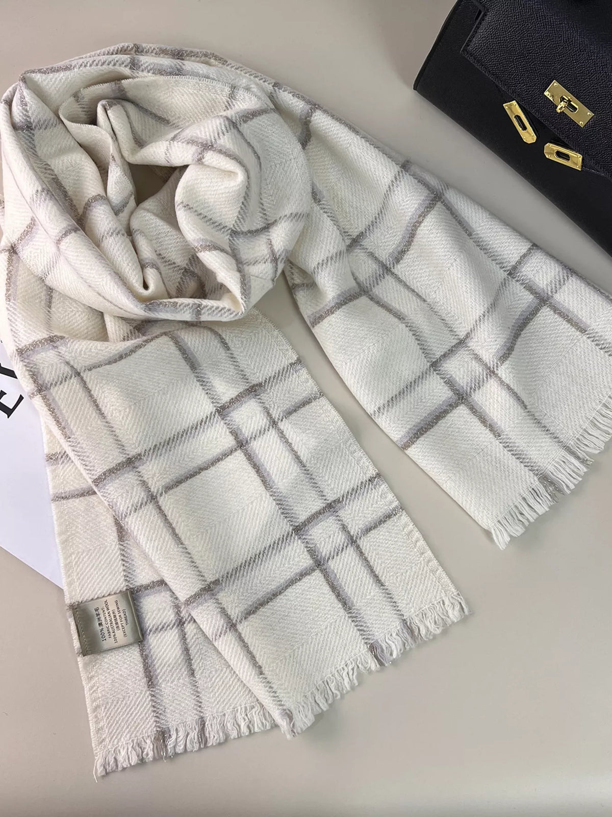 Unisex 100% Wool Raw Hem Plaid Scarf — pale grid scarf arranged loosely on printed pages