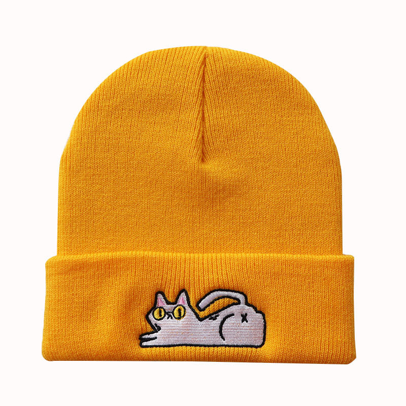 Golden yellow cuffed knit beanie with a small lazy cat motif
