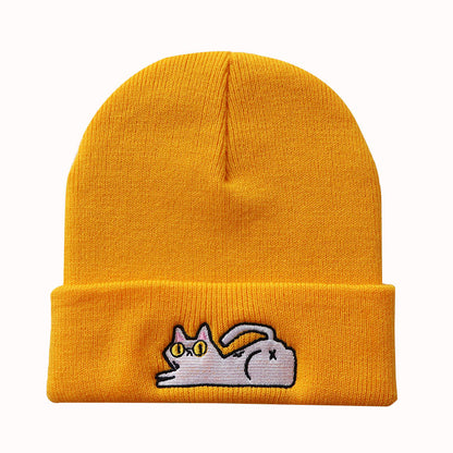 Golden yellow cuffed knit beanie with a small lazy cat motif