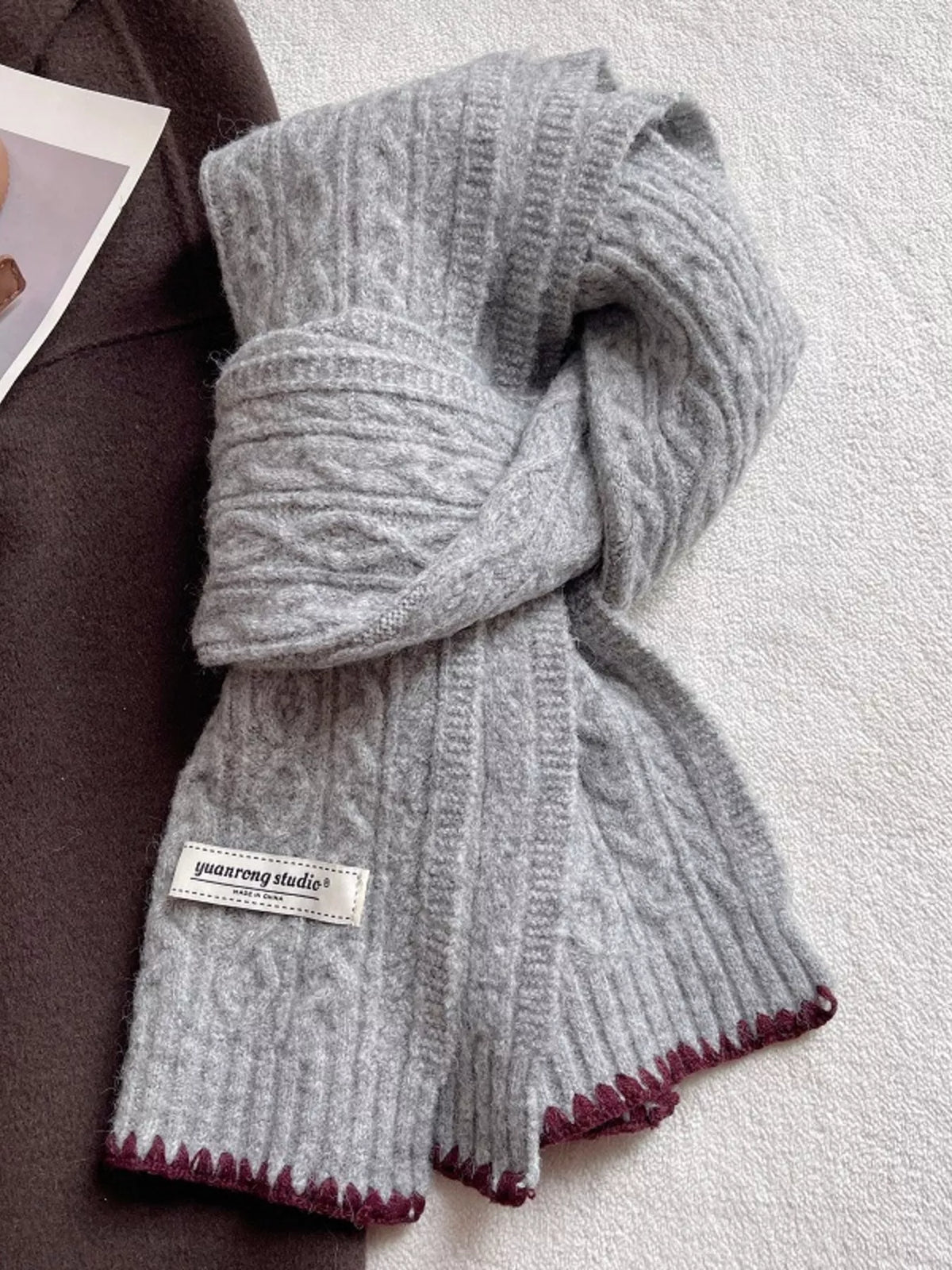 Unisex Cozy Cable Knit Scarf with Contrast Trim — light gray cable scarf tied with dark edge trim visible