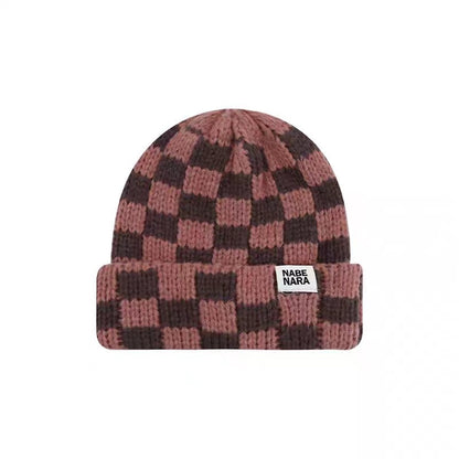Front view of brown pink checkerboard winter beanie on a white background