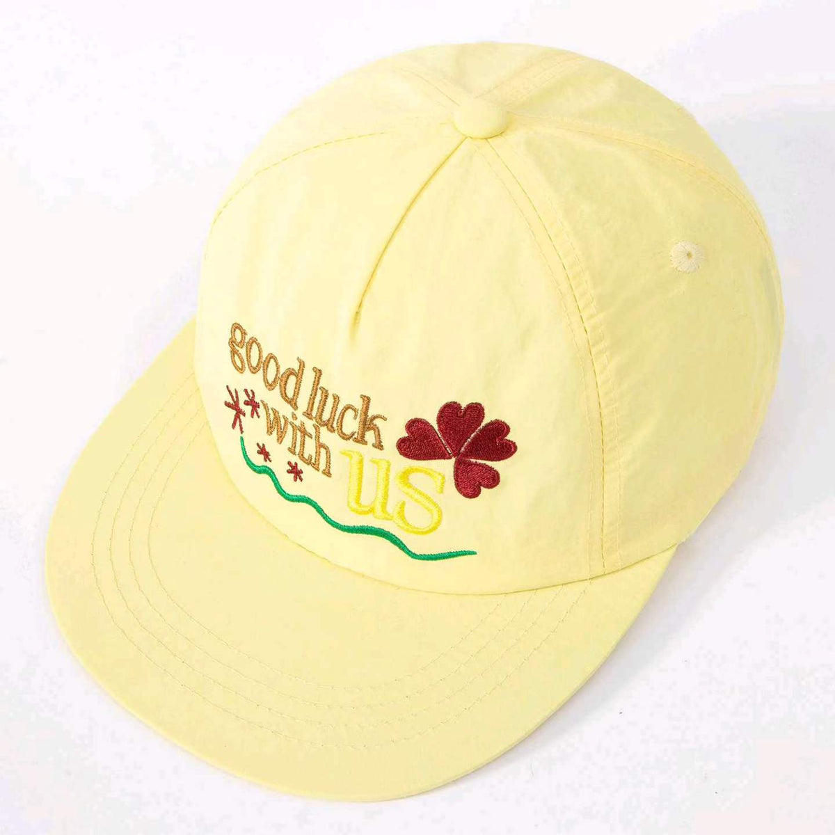 Yellow baseball cap with Good Luck lettering and clover motif