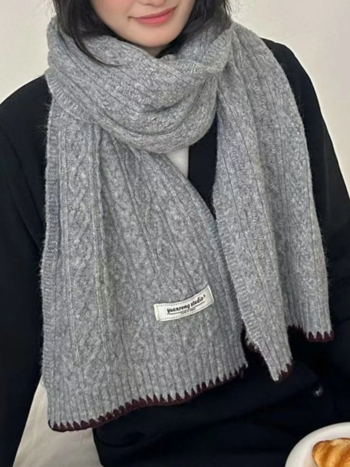 Unisex Cozy Cable Knit Scarf with Contrast Trim — close outfit view of gray cable scarf at the neck