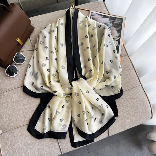 Women's Contrast Border Scarf — beige printed scarf with dark border draped on a chair