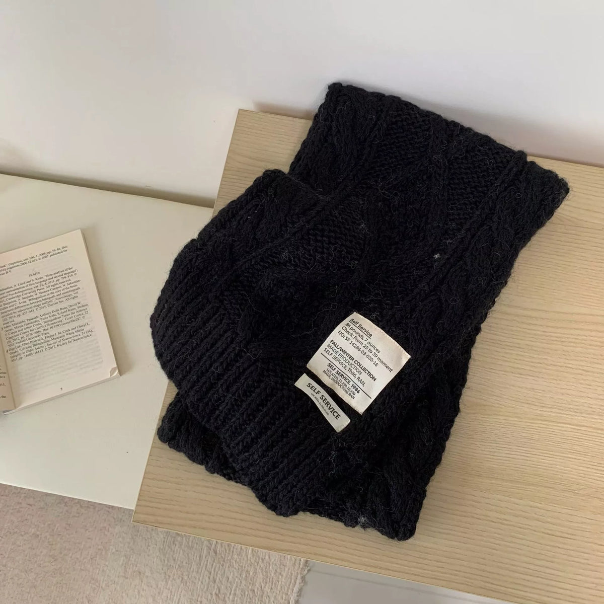Unisex Chunky Cable Knit Scarf — black chunky scarf folded on a light surface