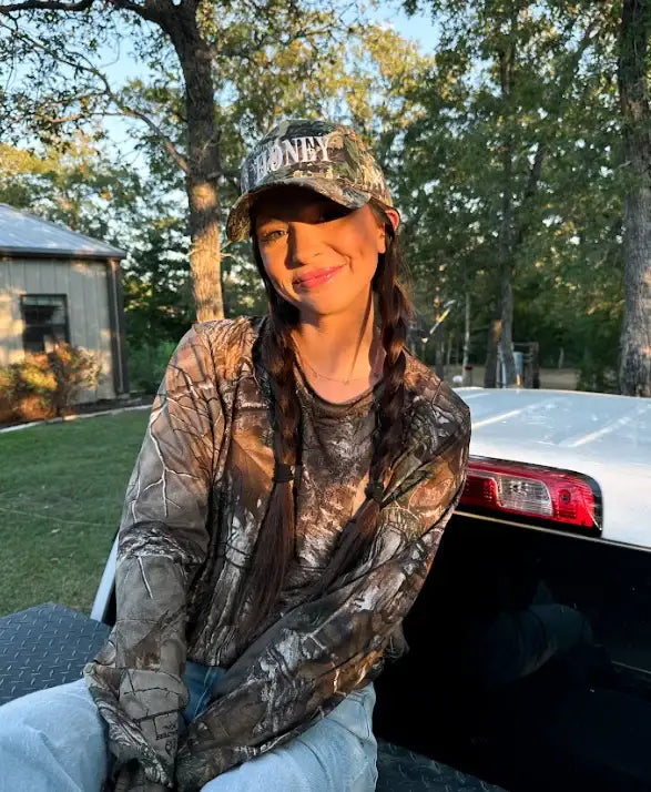 The Mad Hatter Company Honey Snapback, camouflage Honey cap worn by a model outdoors