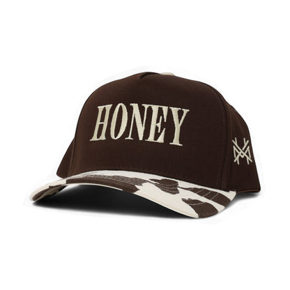 The Mad Hatter Company Honey Snapback, brown crown with a cow-print brim and pale lettering