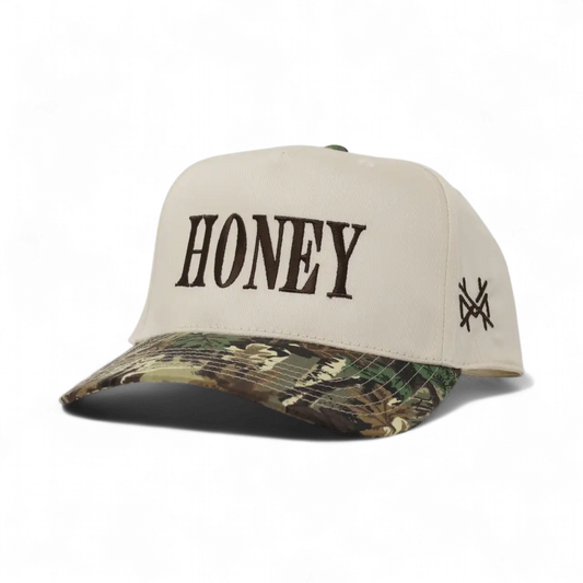 The Mad Hatter Company Honey Snapback, natural crown with a leaf camouflage bill and dark lettering