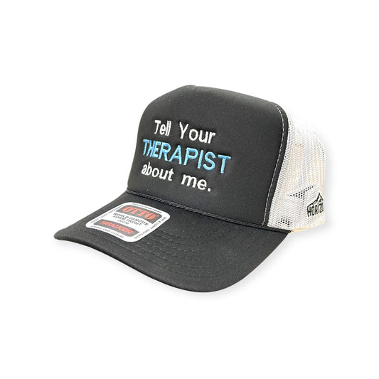 Angled view of Tell Your Therapist About Me embroidered cap by Horizon Hat Co. in black/white showing the bill and side panels