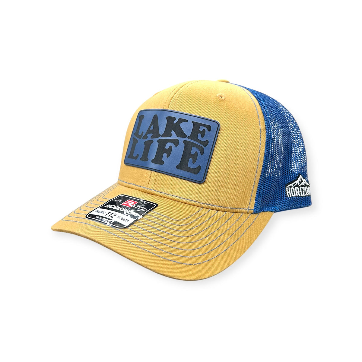 Angled view of Lake Life #2 patch hat by Horizon Hat Co. in biscuit/royal blue showing the curved bill and side panels