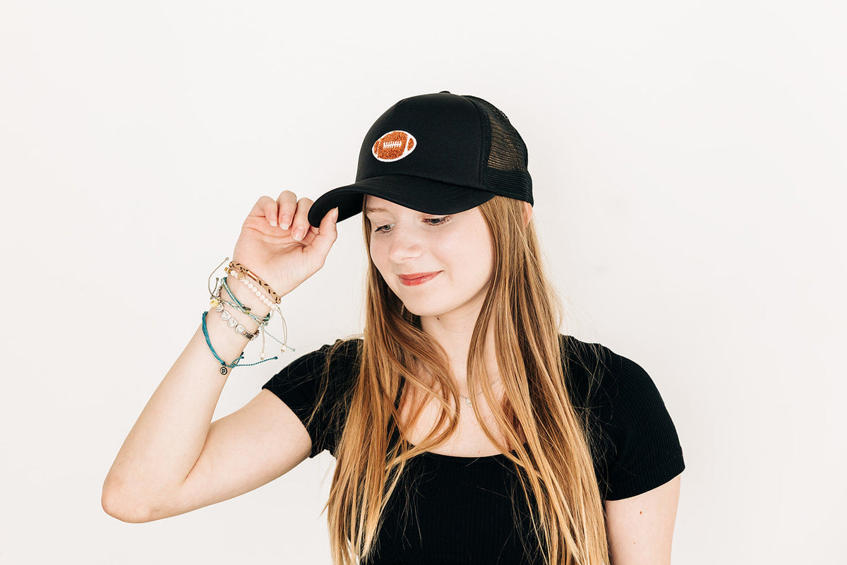Rey To Z person wearing the Black football-patch trucker with a light top